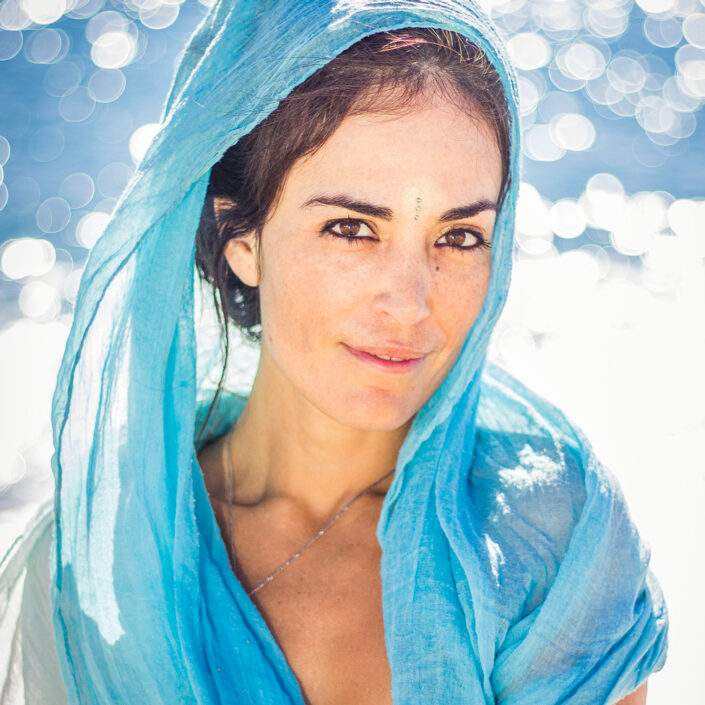 Retrato de mujer con el mar de fondo. Un chal de seda azul en concordanza con el azul del mar le cubre la cabeza.